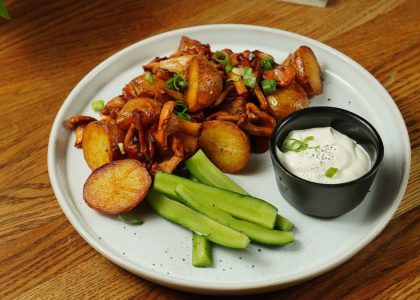 A delectable plate of roast potatoes served with chanterelle mushrooms and fresh cucumbers.